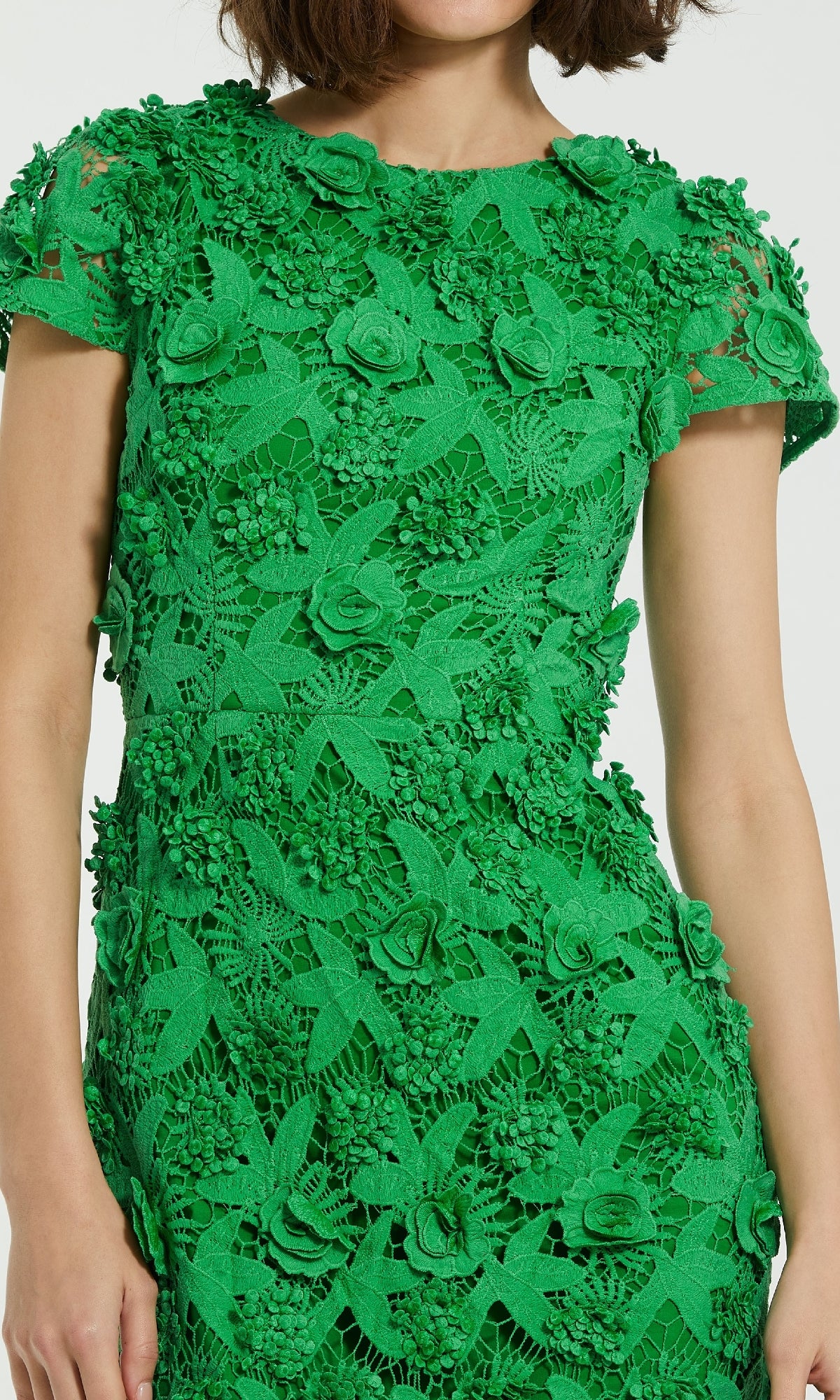 A woman wearing the Mac Duggal 81022 Midi Lace Cocktail Dress in green, featuring intricate 3D floral and leaf lace detailing.